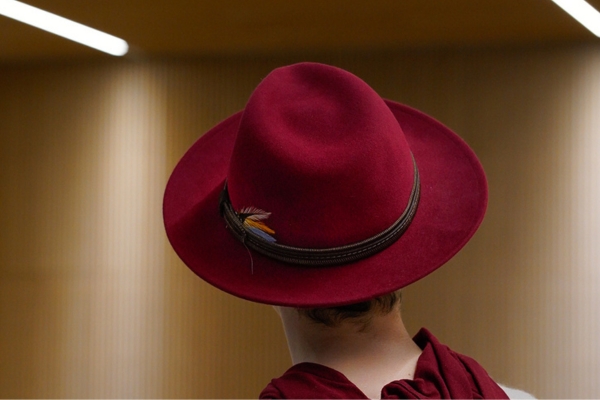 Portrait artistique de dos de Sylbohec, artiste photographe au chapeau bordeaux